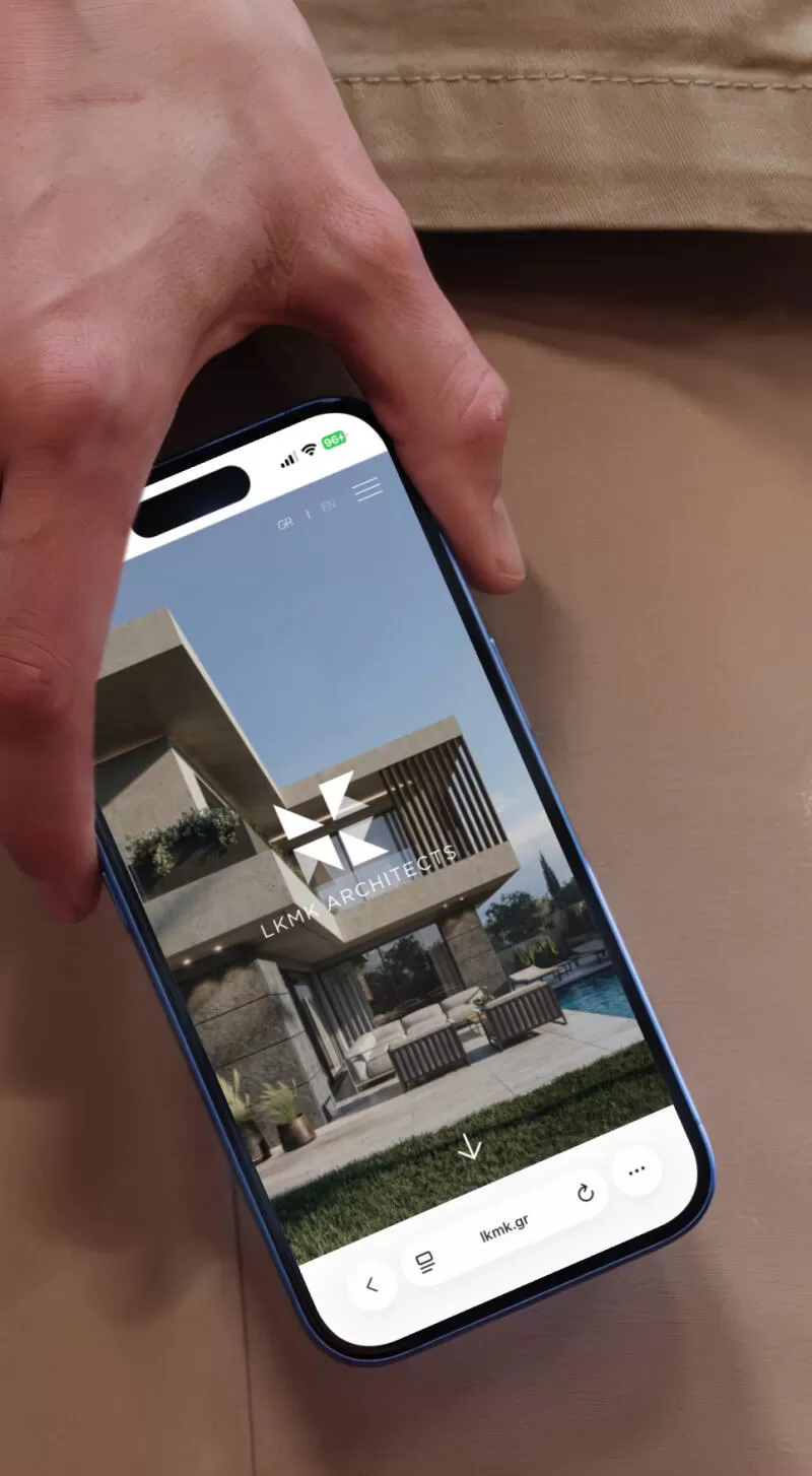 mockuuups iphone 16 mockup held by a person against a concrete wall
