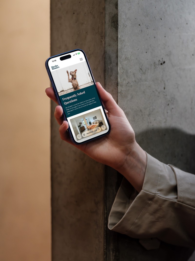 mockuuups iphone 16 mockup held against a concrete wall